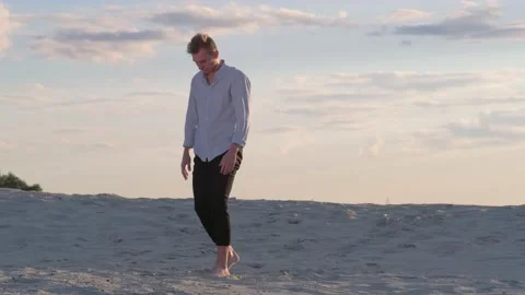 Guy dancing contemporary choreography on the sand at sunset. Slow motion Stock Footage 135611571