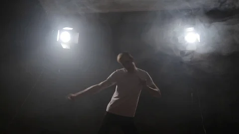 Guy dancing in the dark in the backlight Video stock 80834363