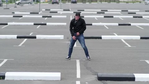 Guy dancing hip hop in the car parking. Contemporary choreography. Slow motion Stock Footage 138808314