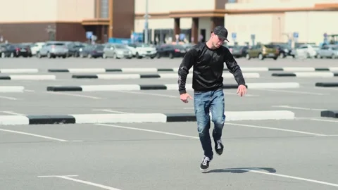 Guy dancing hip hop in the car parking. Contemporary choreography. Slow motion Stock Footage 138808328