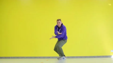 Guy dancing hip hop, modern choreography in the studio against a yellow wall. Stock Footage 139756524