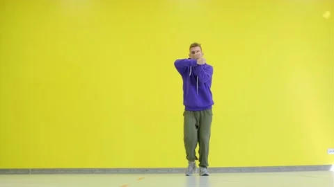 Guy dancing hip hop, modern choreography in the studio against a yellow wall. Stock Footage 139756665