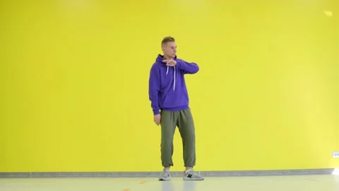 Guy dancing hip hop in the studio against a yellow wall. Isolated. Stock Footage 139756329