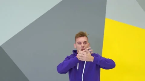 Guy dancing hip hop in the studio in front of the wall with geometric pattern Stock Footage 142820127