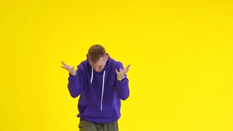 Guy dancing modern dance in the studio against the background of a yellow wall Stock Footage 142820182