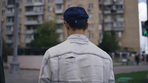 A guy in a denim jacket is walking around the city Stock Footage 160336211