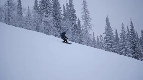 Guy descends from the mountain on snowboard in slowmo Vidéo 71012929