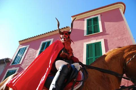Guy with a devil's mask riding a horse Stock Photos