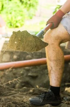 Guy is digging ground. Man with shovel. Digging up soil. Work on land. Stock Photos