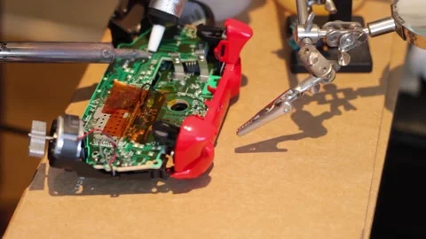 A guy disassembling the old solder from the Xbox controller. Stock Footage 151855777
