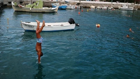 Guy dives into the water from the pier. Stock Footage 119269890