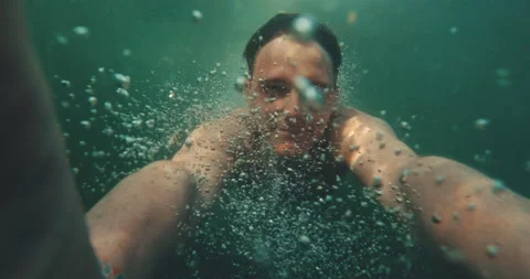 Guy diving ocean looking at the camera 4k Stock Footage 153776165