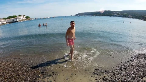 The guy does a back flip on a mediterranean sea beach in Cadaqués Spain Stock Footage 196788669