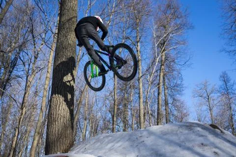 Guy does a bike trick in the winter. Man shows Moto whip trick on a bicycle. Stock Photos