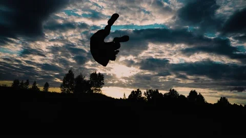 The guy does a forward somersault against the background of the evening sky Stock Footage 158127083