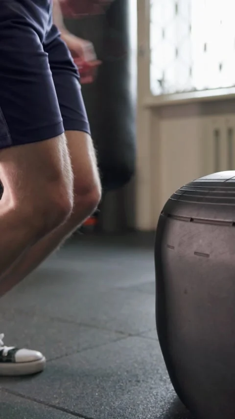 A guy does a hard workout, jumps on a big tire and becomes very strong. Vídeos de archivo 302433246