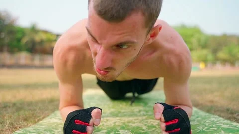 The guy does the plank exercise, trying hard and emotionally. Stock Footage 231336491