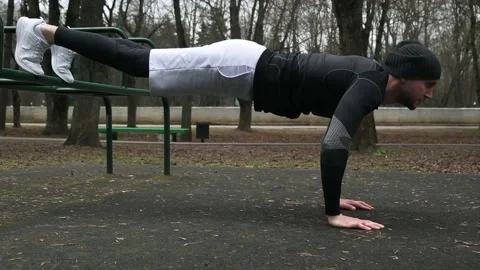 A guy does push-ups on a sports field on the street, a man does sports Stock Footage 237988283