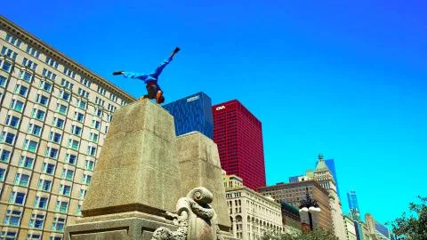 The guy does tricks on a concrete column in the city center. Stock Photos