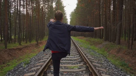 The guy does the warm-up before jogging on rails in the forest. Stock Footage 93975210