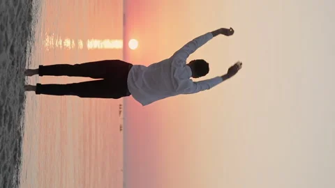 The guy does a warm-up on the seashore Stockbeeldmateriaal 145925474