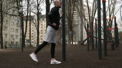 A guy does a warm-up on a sports field on the street, a man does sports Stock Footage 237993908