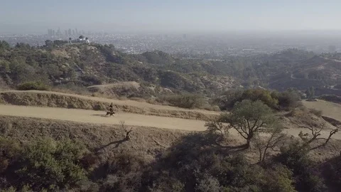 Guy with Dog running down hiking trail with LA city view in background 動画素材 82246512