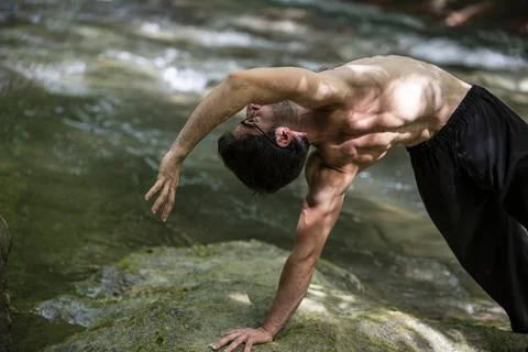 Guy doing bareback yoga on the river Stock Photos