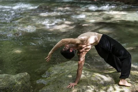 Guy doing bareback yoga on the river Stock Photos