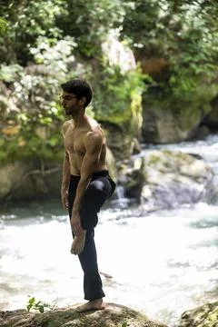 Guy doing bareback yoga on the river 스톡 사진