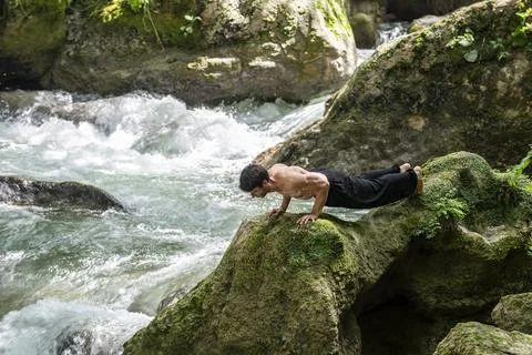 Guy doing bareback yoga on the river Stock Photos