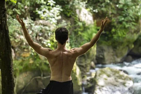 Guy doing bareback yoga on the river Foto stock