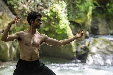 Guy doing bareback yoga on the river Stock Photos