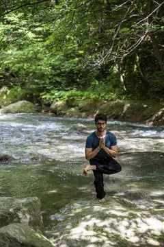 Guy doing bareback yoga on the river Foto stock