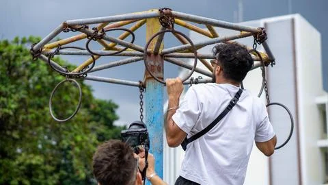 Guy doing a pull-up in a street workout, with building in the background Stock Photos
