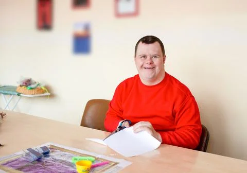 A guy with down syndrome does needlework. Stock Photos