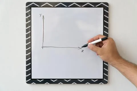 The guy is drawing a schedule on a white board. Male hand with a marker on a  Stock Photos
