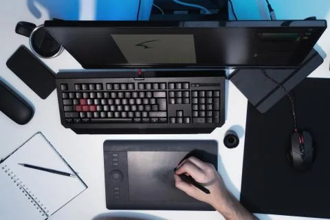The guy draws on a graphic tablet. White desktop Stock Photos