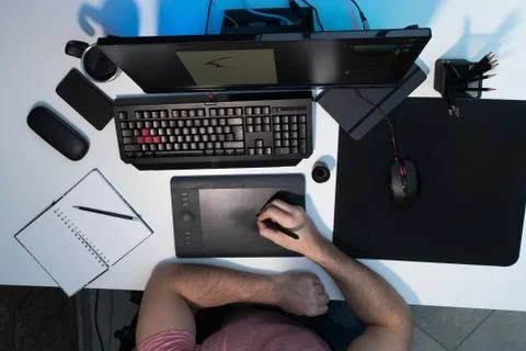 The guy draws on a graphic tablet. White desktop Stock-Fotos