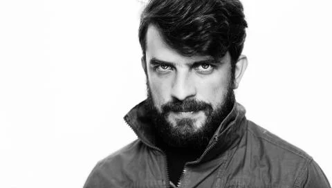 Guy dressed in khaki jacket with interesting look. Close.up. White Stock Photos