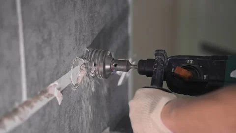 The guy is drilling the wall with a diamond bit Stockbeeldmateriaal 147077373