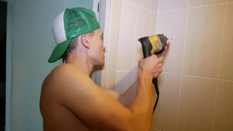 Guy drilling a wall, in the hands holding the drill. Stock Footage 122375577