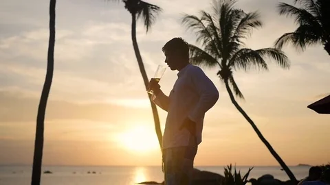The guy drink beer on the beach.Sunset time Vidéo 76313019