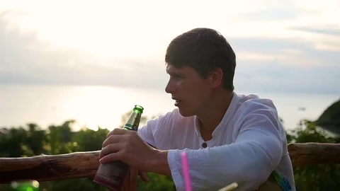 The guy is drinking a beverage at the beach bar. Panoramic view 库存影片 75052453