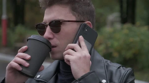 Guy drinking coffee and talking on the phone Stock Footage 219229409