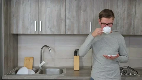 Guy is drinking hot strong coffee from a white cup while take a break from work. Stock Footage 144334698
