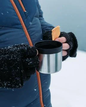 Guy drinking tea and snacking near beautiful winter lake Foto stock