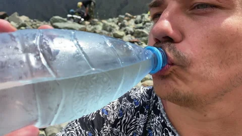 Guy drinks clean mountain cold water from a plastic bottle Video stock 158018748