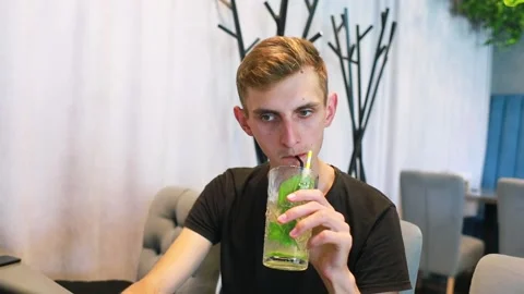 A guy drinks a cocktail in a cafe. Stock Footage 201824284