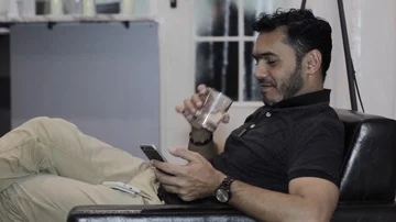 The guy drinks coffee and uses a mobile device in the hotel Stock-Footage 85642052